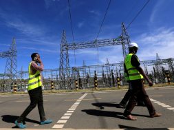 FILE PHOTO: Kenya Electricity Generating Company workers walk past the pylons of high-tension electricity power lines at the Olkaria II Geothermal power plant near the Rift Valley town of Naivasha