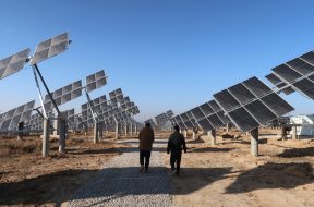 Workers walk at a solar power station in Tongchuan, Shaanxi
